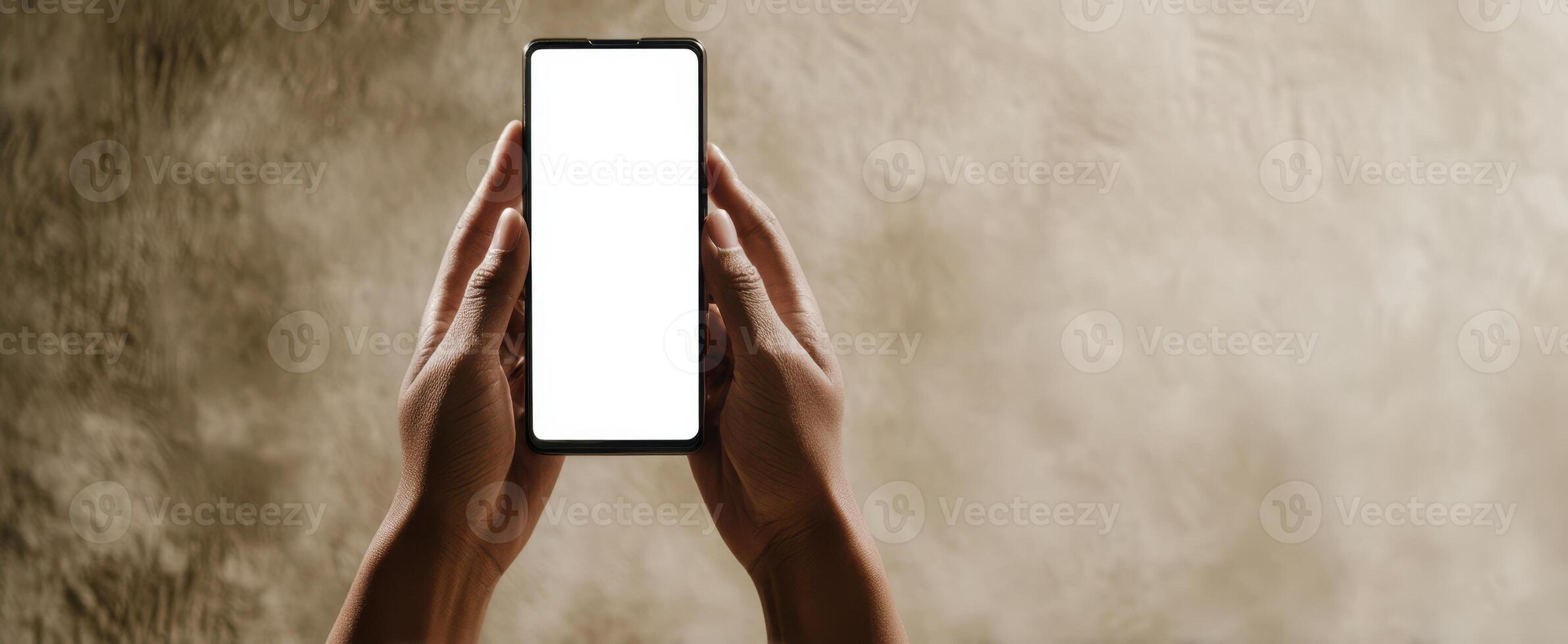 The smartphone held in hands against a soft textured background. photo