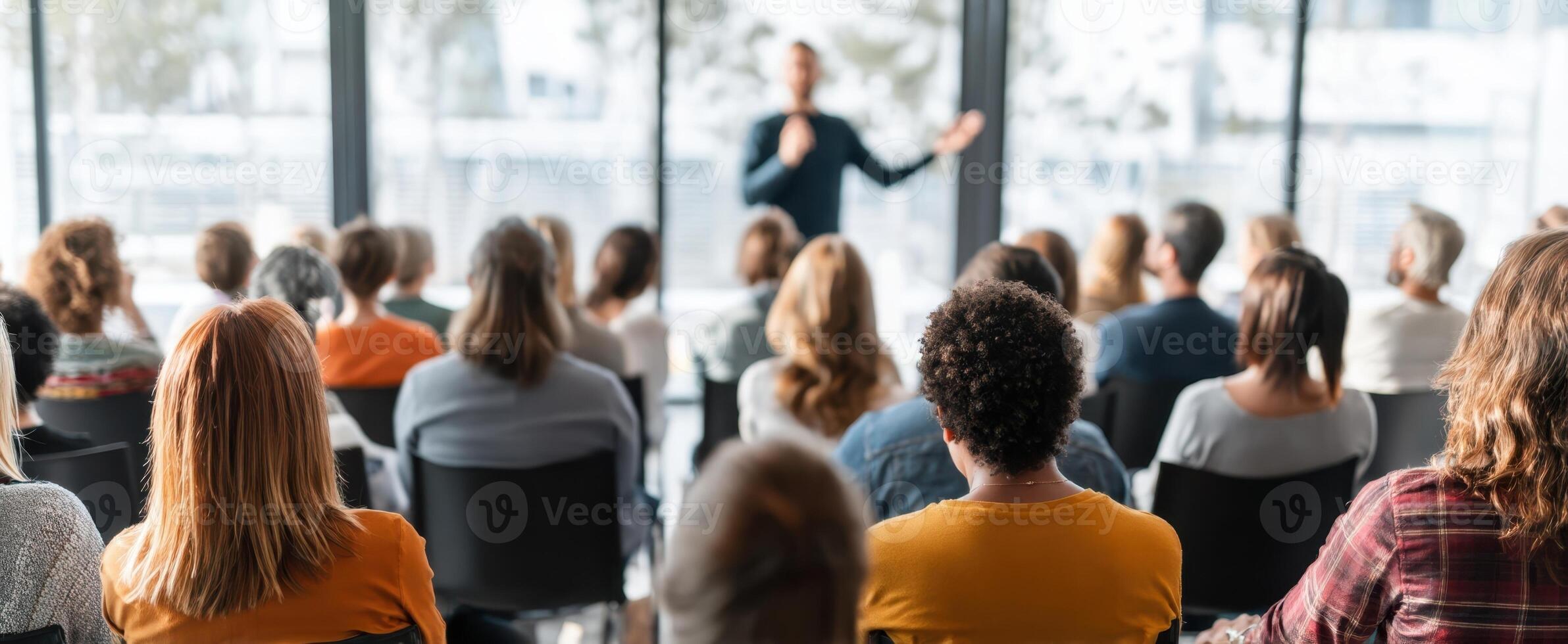 The engaged audience listening intently to a presentation in a modern conference room. photo