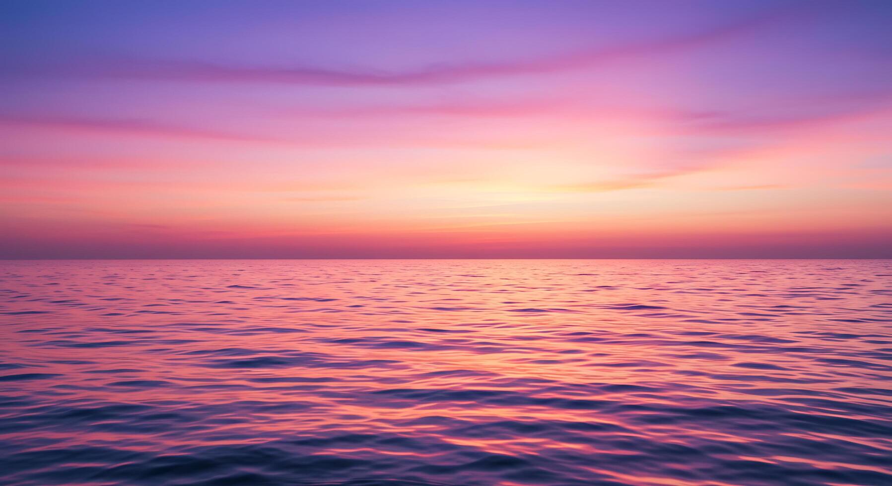 A beautiful sunset over the ocean with a purple sky photo