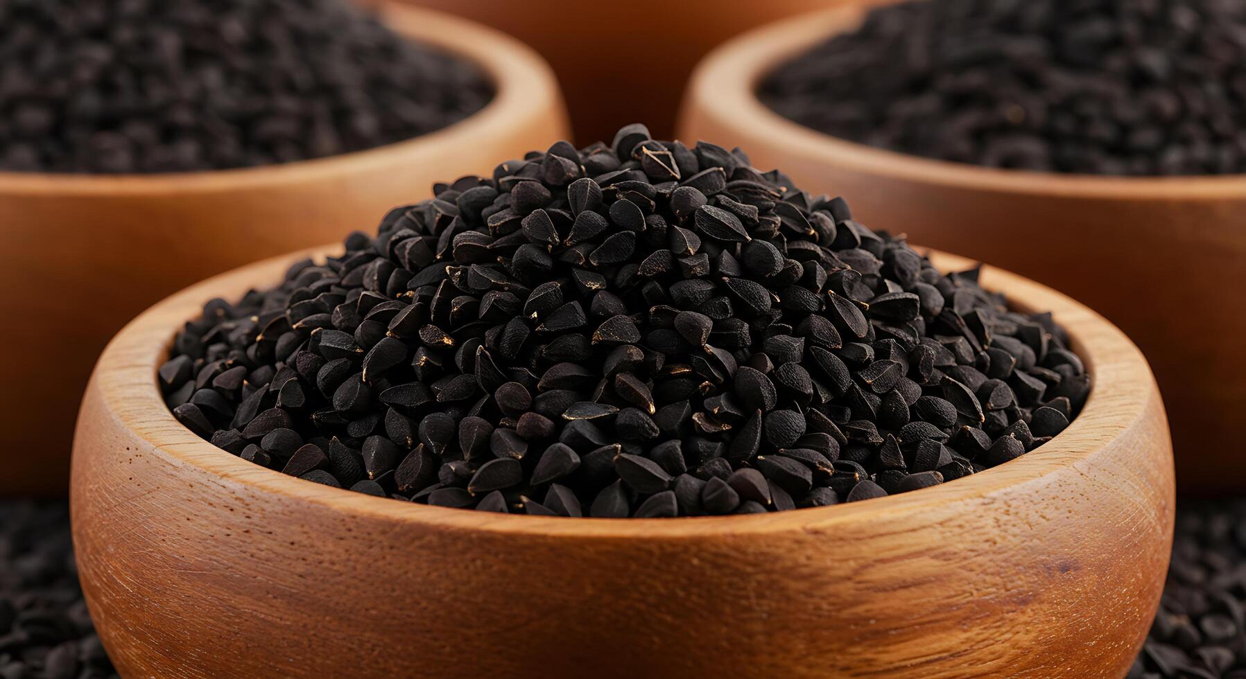 Black cumin seeds in wooden bowls photo