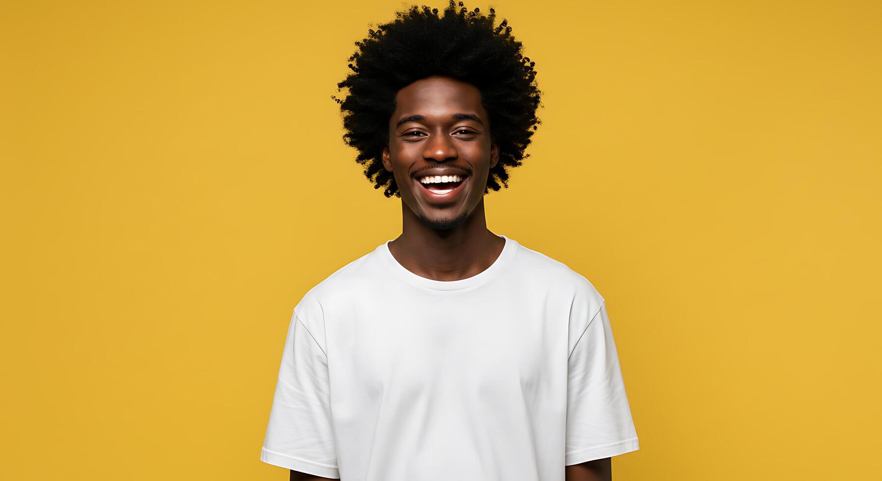 A man with afro hair smiling and wearing a white t - shirt photo