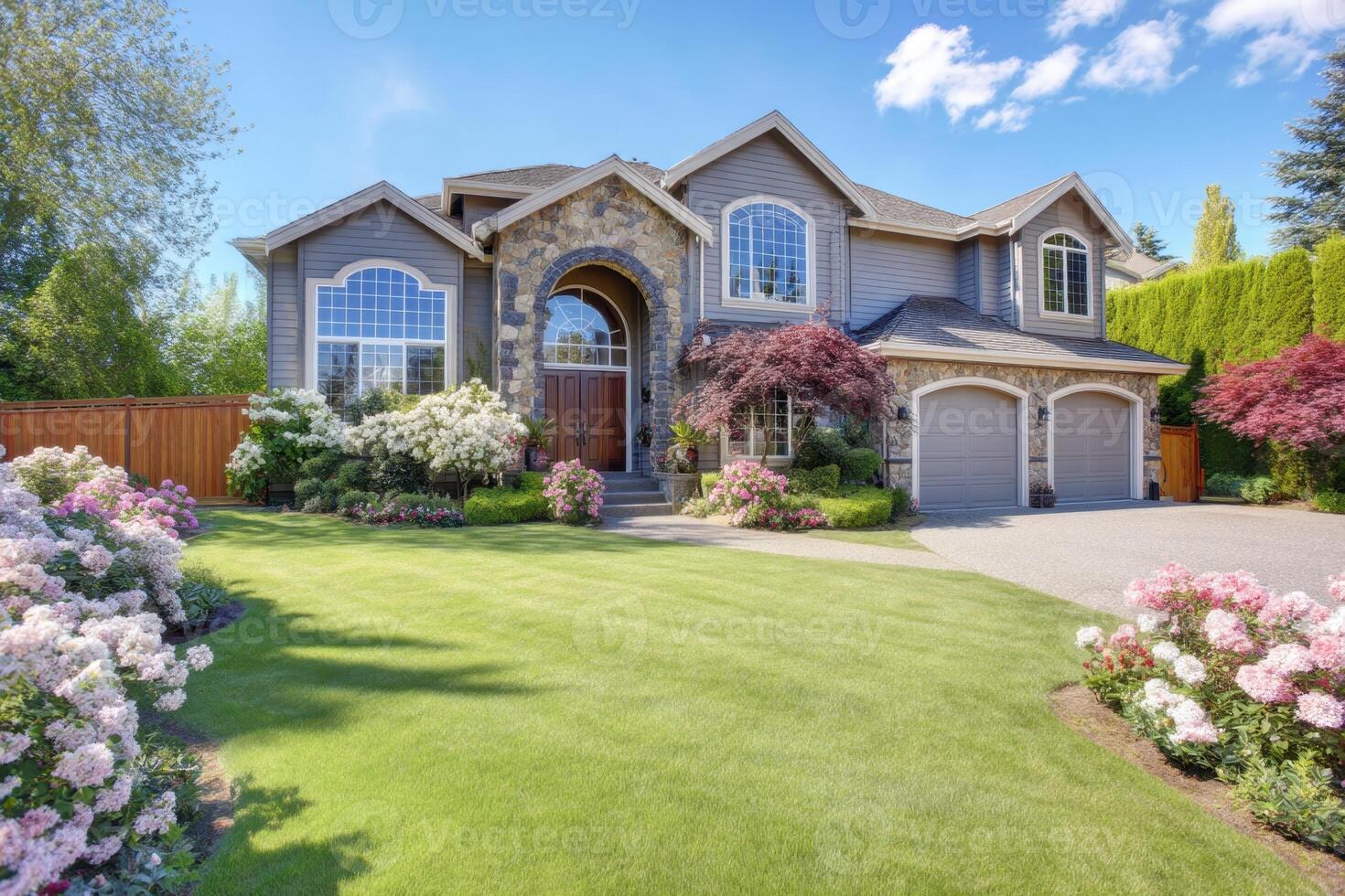 A beautiful home with a large driveway and flowers photo