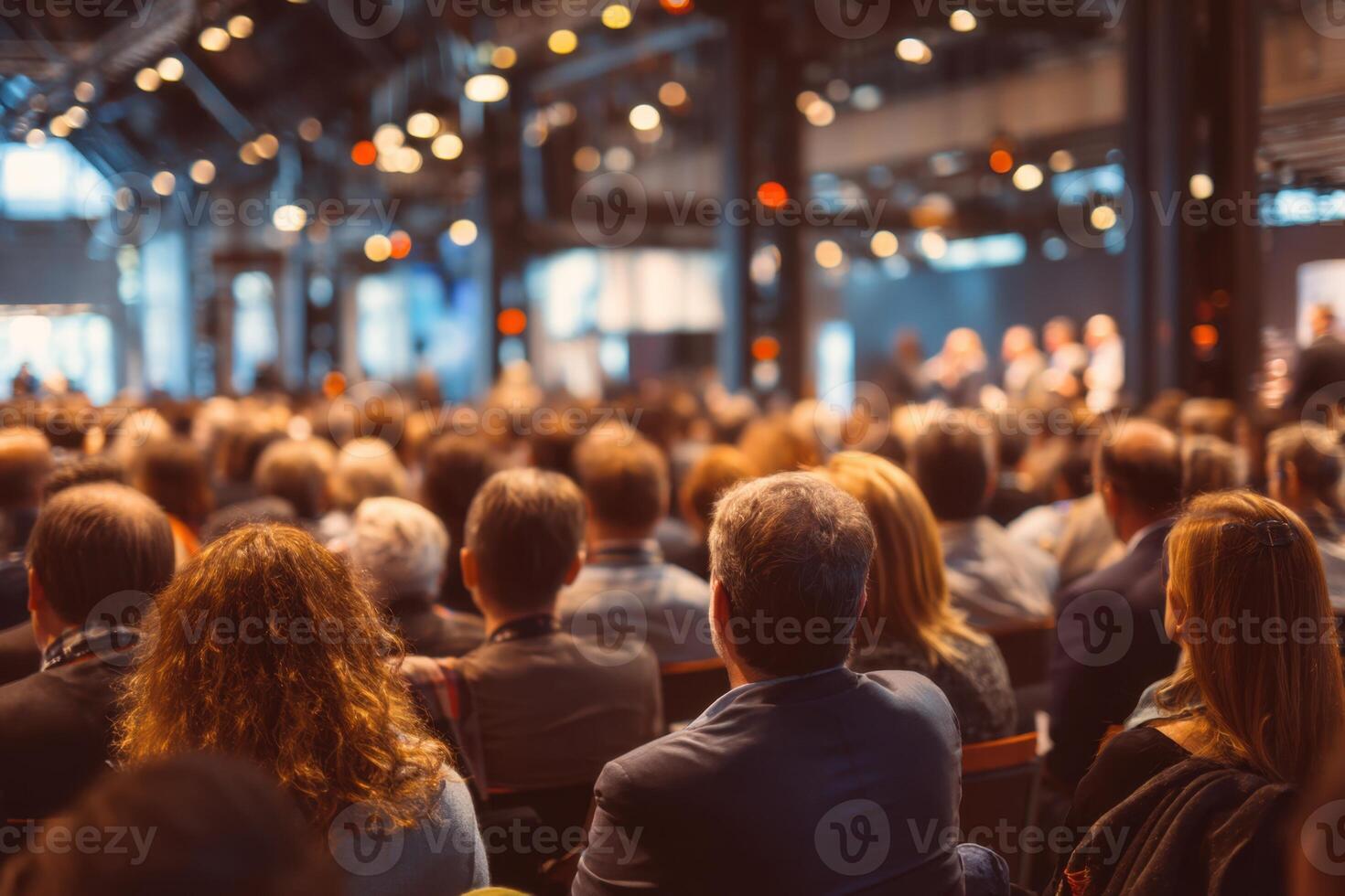 Large Audience Attending Seminar Listening to Speaker with Bright Lights at Venue photo