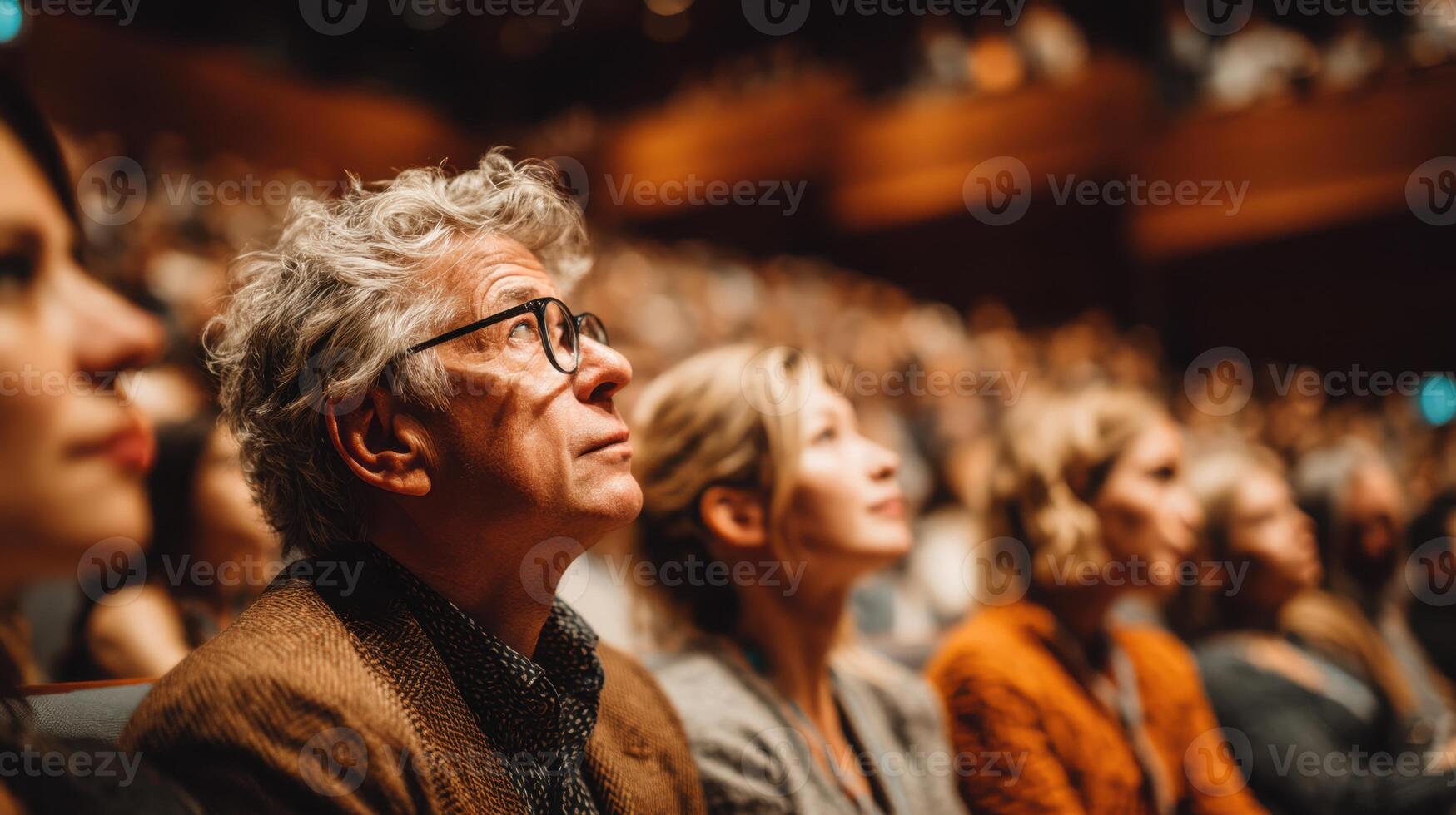 Engrossed Audience Watching a Performance Inside a Theater Full of People photo