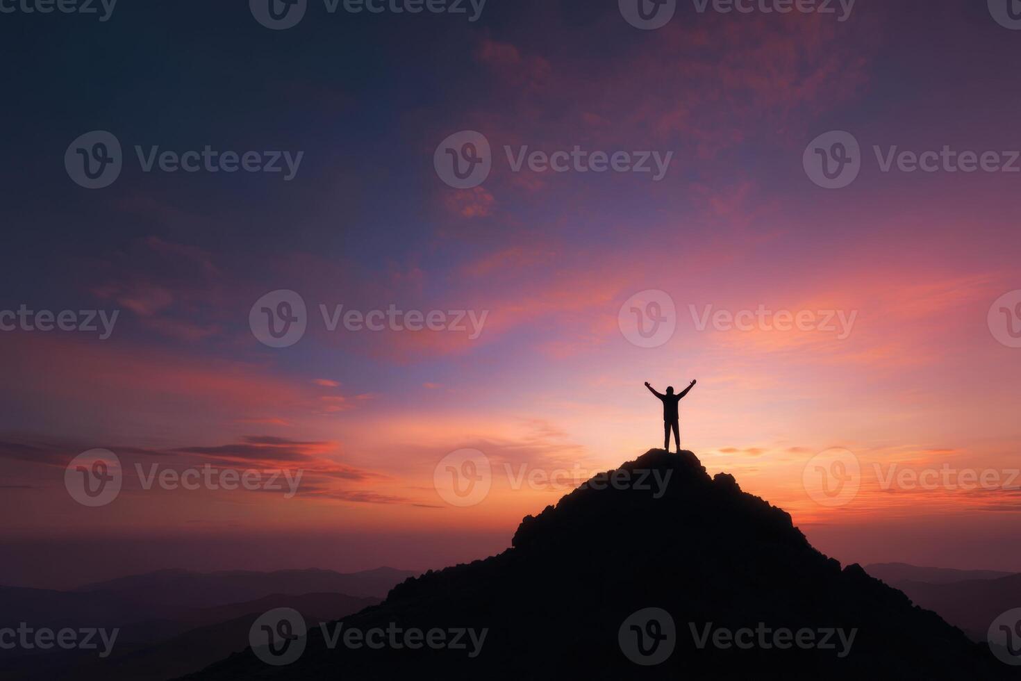 Silhouette of a person on a hilltop at sunrise or sunset photo