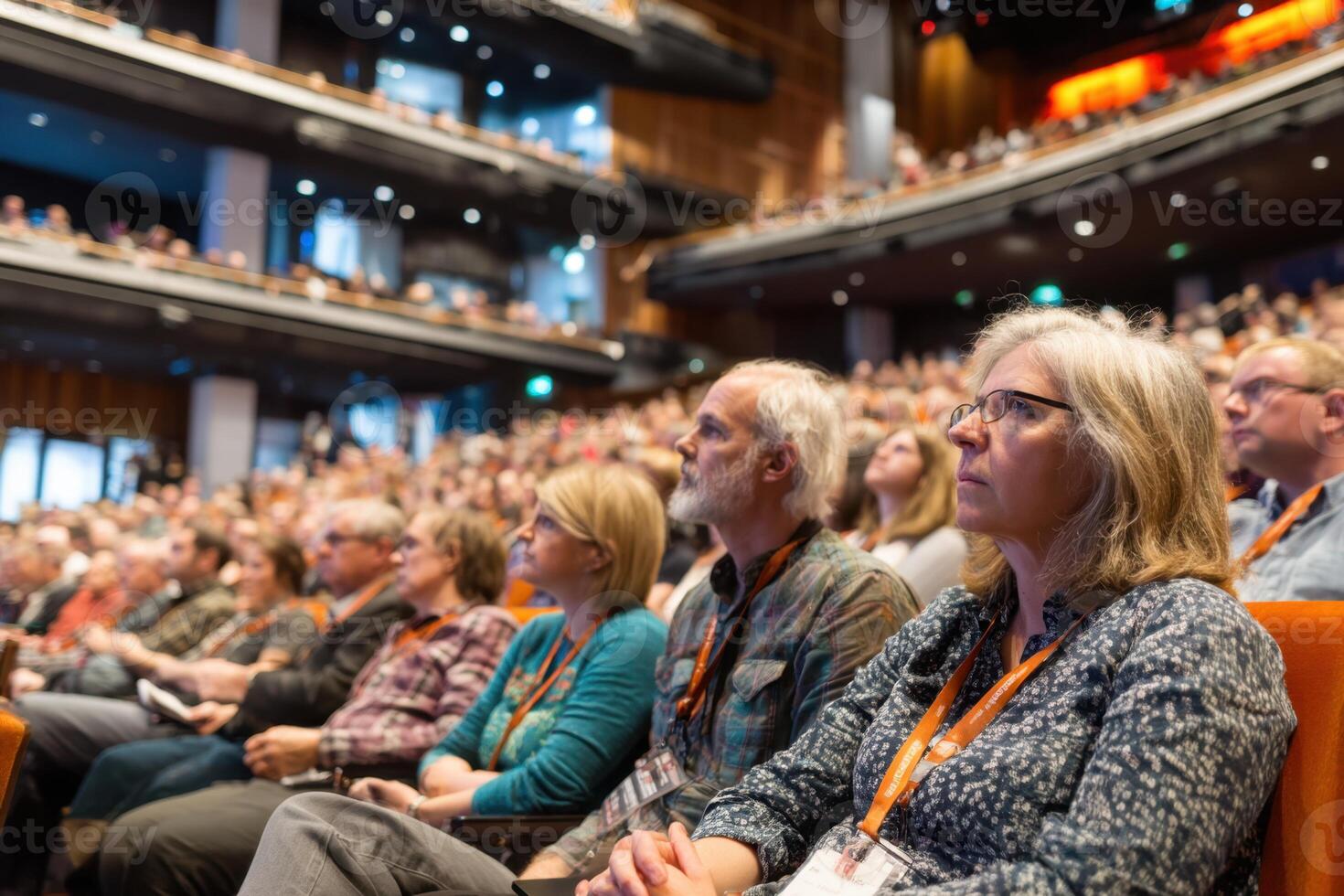 A Packed Auditorium Filled with People Listening Attentively to a Speaker photo