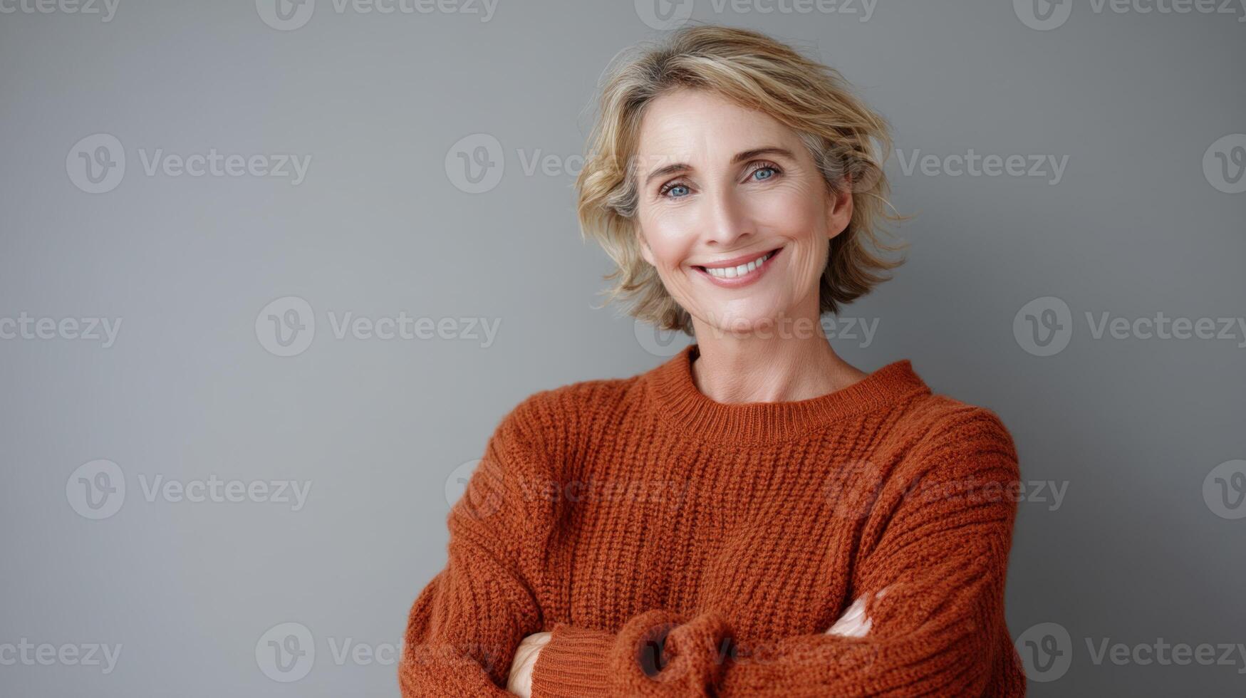 Portrait Of A Beautiful Mature Woman Standing And Smiling On Gray Background photo
