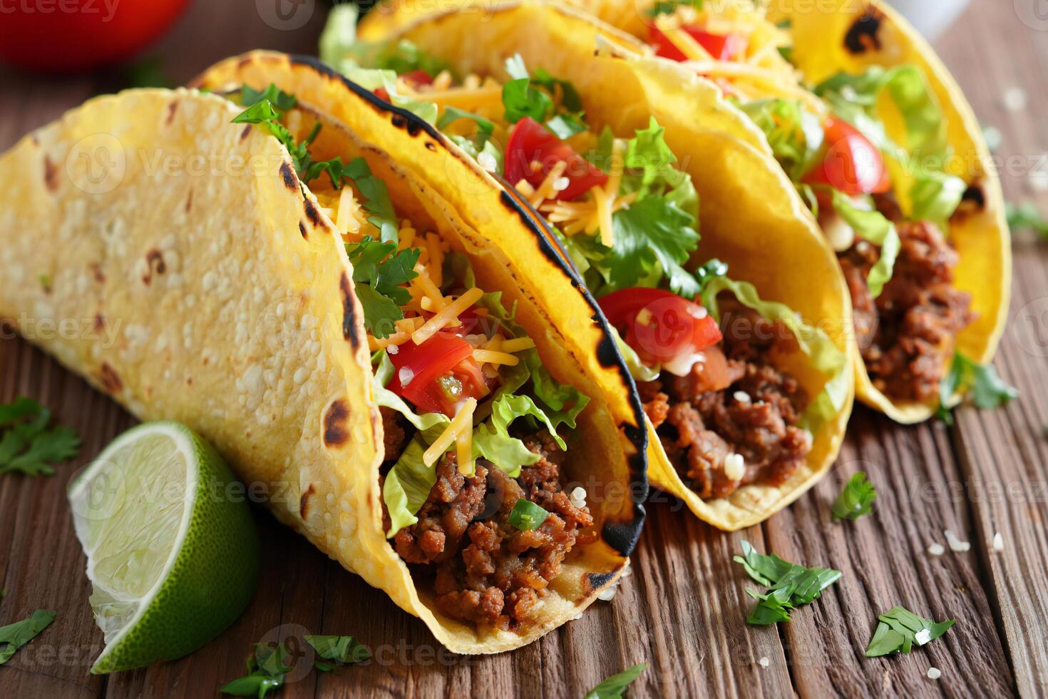 Three tacos with meat and vegetables on a wooden table photo