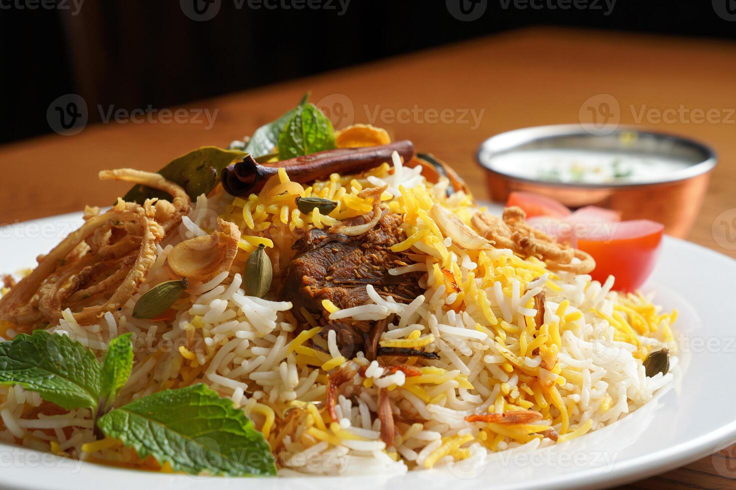 A plate of rice and meat on a table photo