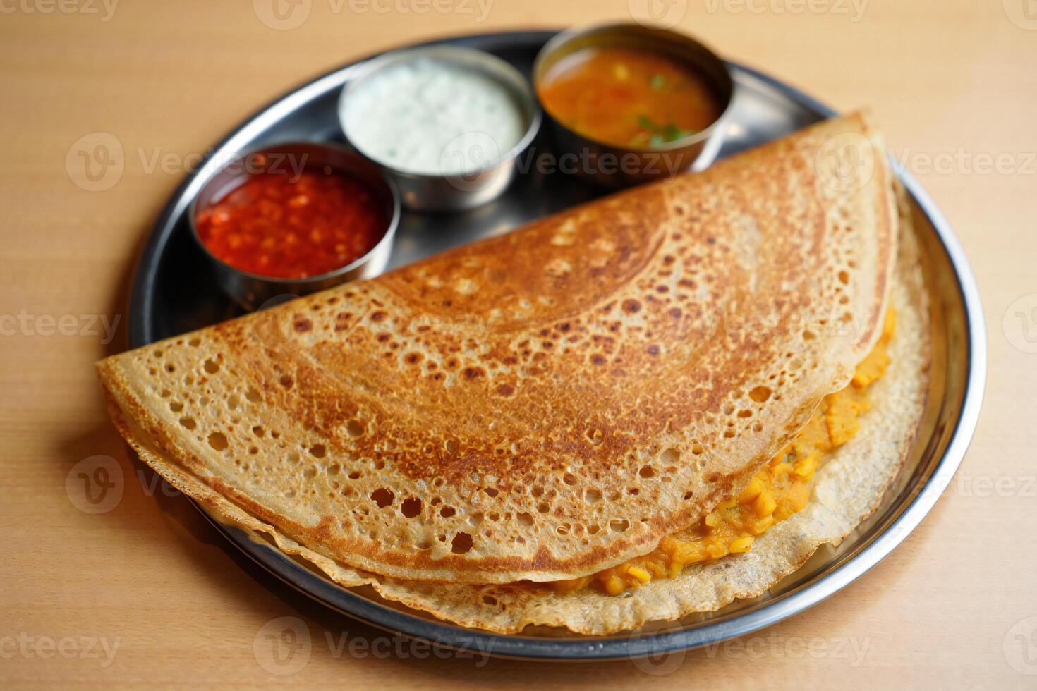 A plate with a crepe and some sauces on it photo