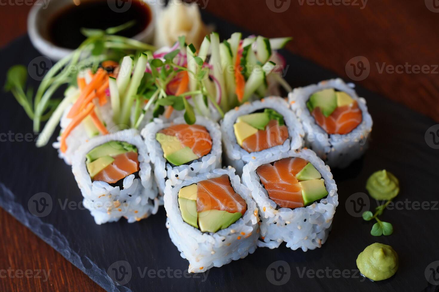 Sushi rolls with salmon, cucumber, avocado and other vegetables photo