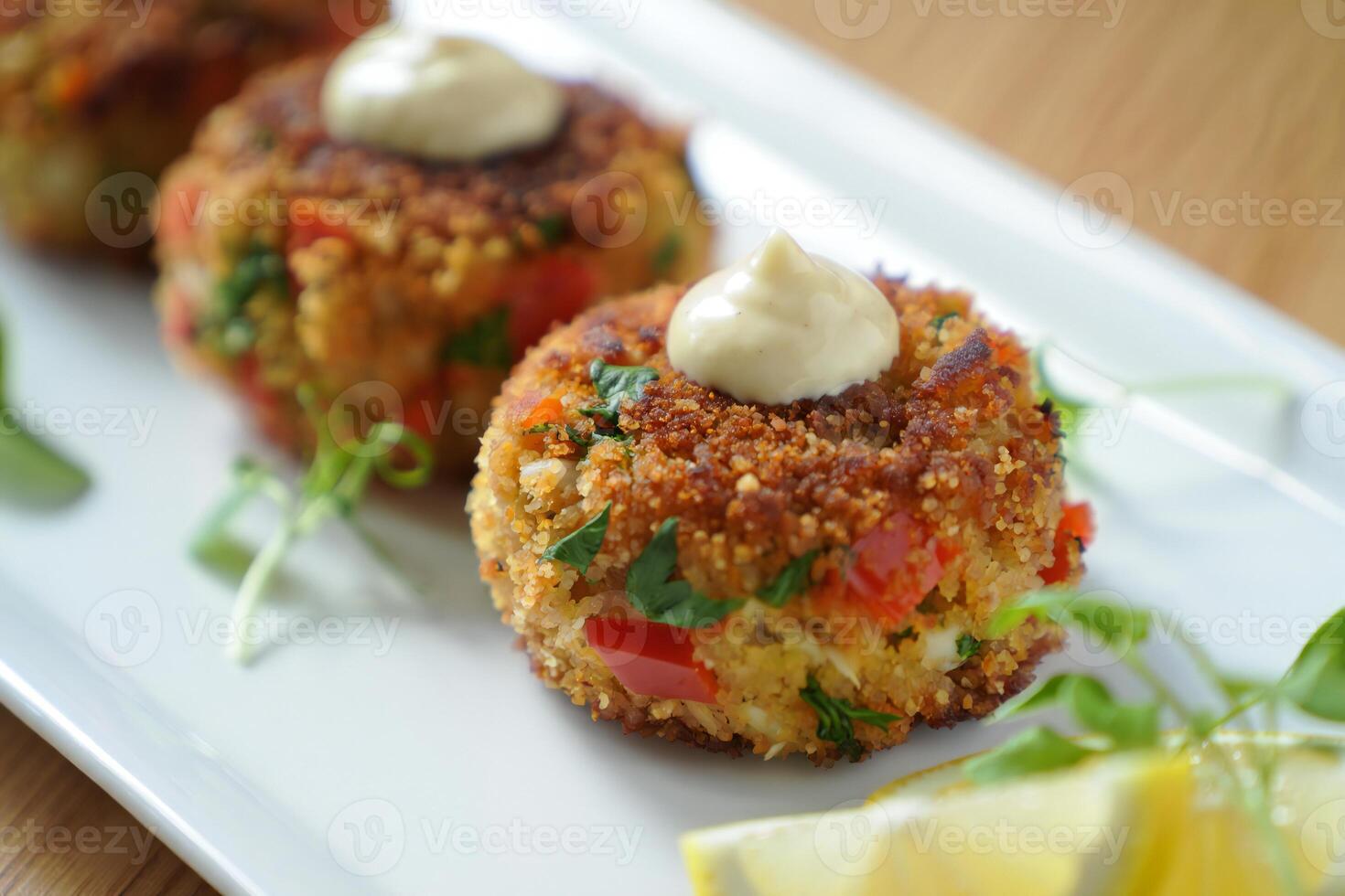 A plate with three crab cakes on it photo