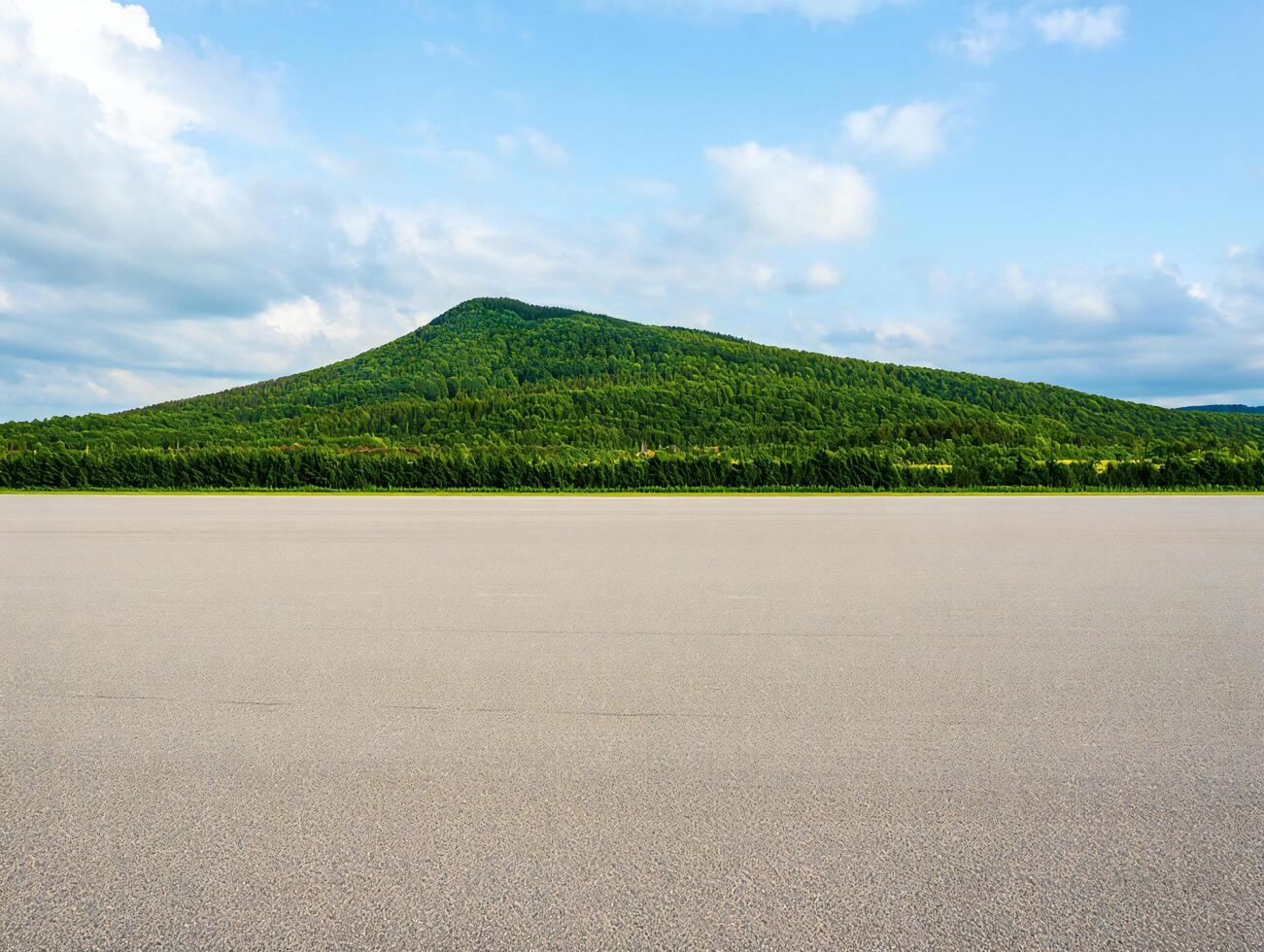 Nature Background Scenic Asphalt Road Leading to Lush Green Mountain Under a Blue Sky with Clouds photo