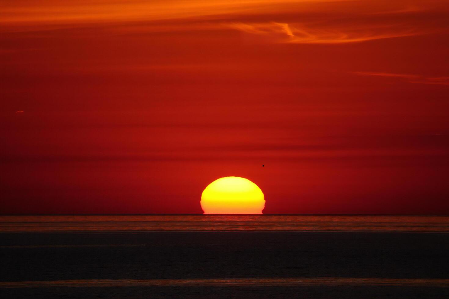 Beach Background Dramatic Ocean Sunset with Bright Yellow Sun and Red Sky Seascape Photography photo
