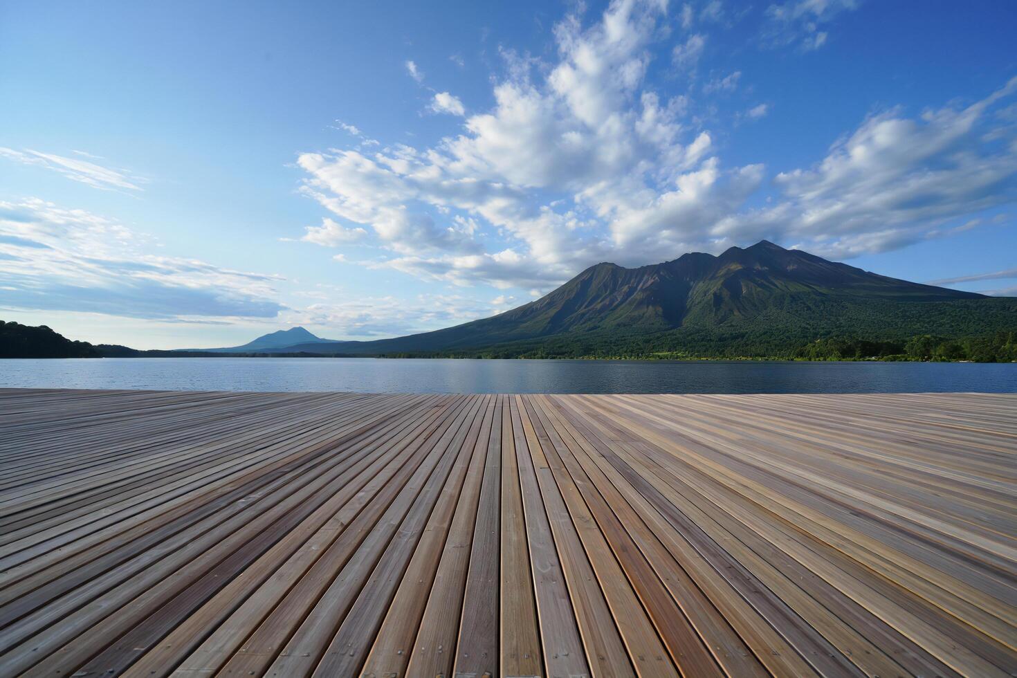Beach Background Serene Lakeside Wooden Deck with Mountain View Tranquil Nature Scene photo
