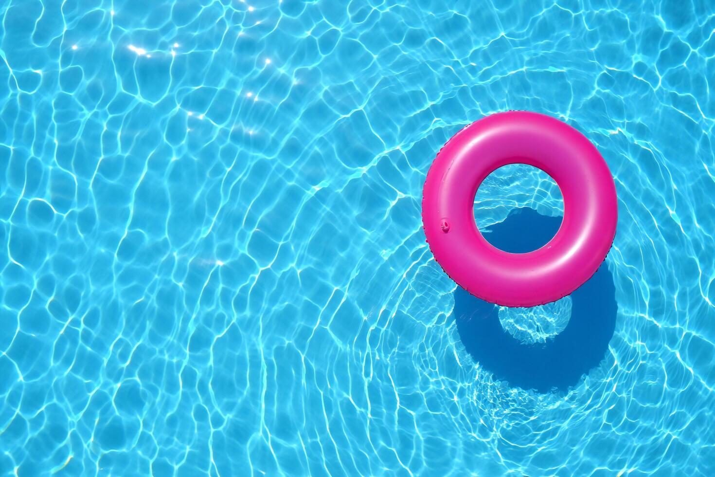 Beach Background Pink Inflatable Ring Floating in a Sparkling Blue Swimming Pool Summer Vacation Relaxation photo