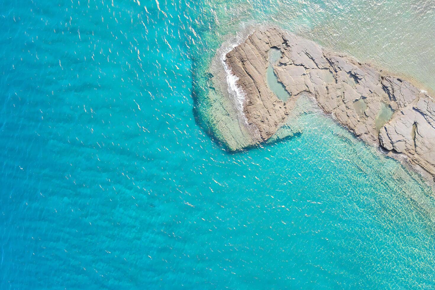 Beach Background Aerial View of Turquoise Ocean Water with Rocky Outcrop Clear Shallow Water Summer Seascape photo