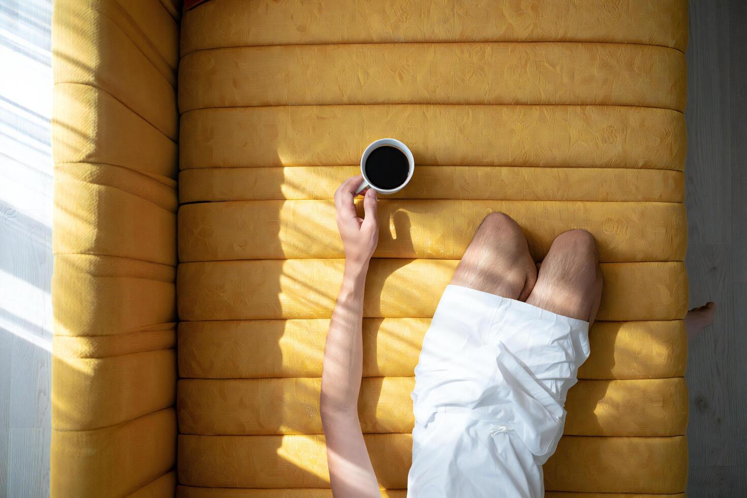 Coffee Background Relaxed Man on Yellow Sofa Enjoying Morning Coffee Sunlight Top View photo