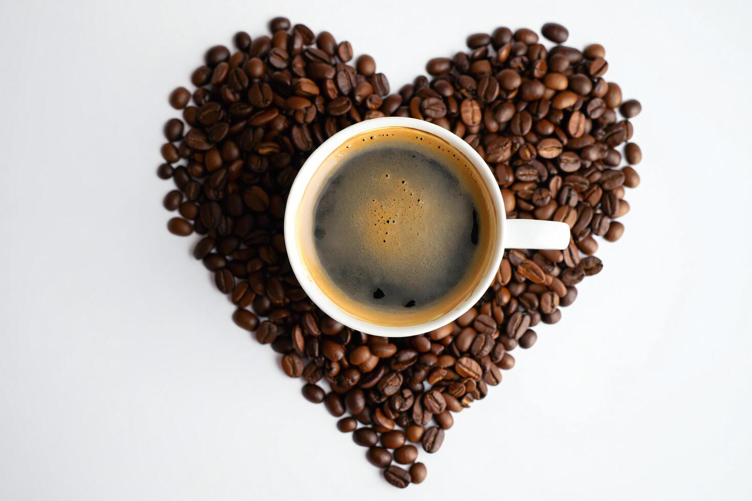 Coffee Background Aromatic Black Coffee in White Mug on Heart Shaped Coffee Beans photo