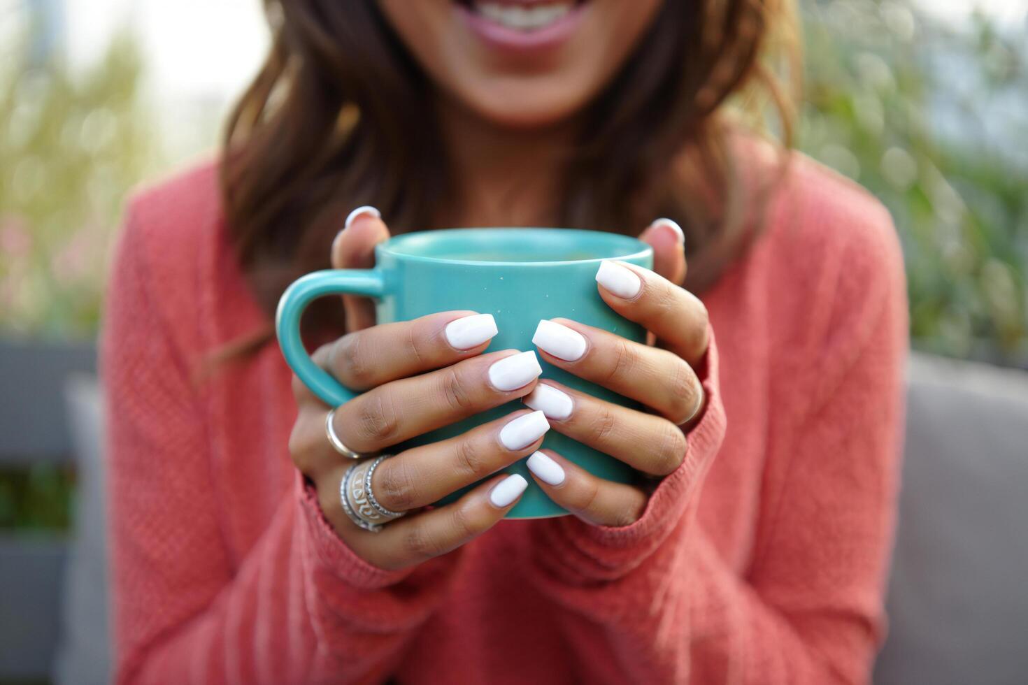 Coffee Background Woman with manicured nails holding a teal mug of coffee enjoying a warm drink photo