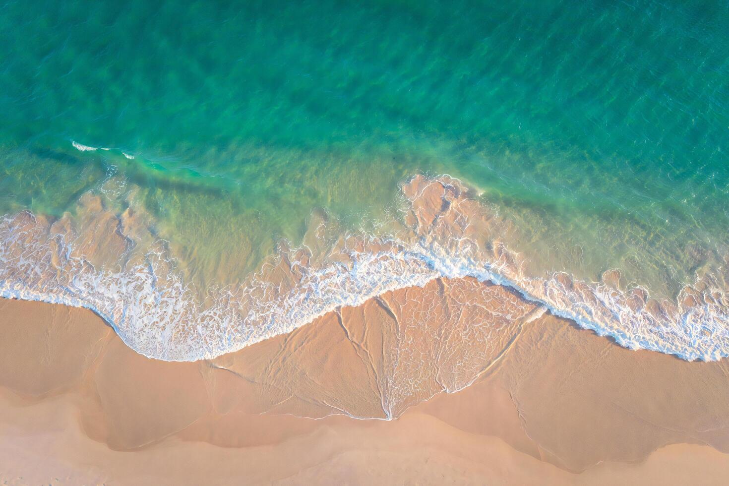 Nature Background Stunning Aerial View of Turquoise Ocean Waves Crashing on Sandy Beach photo