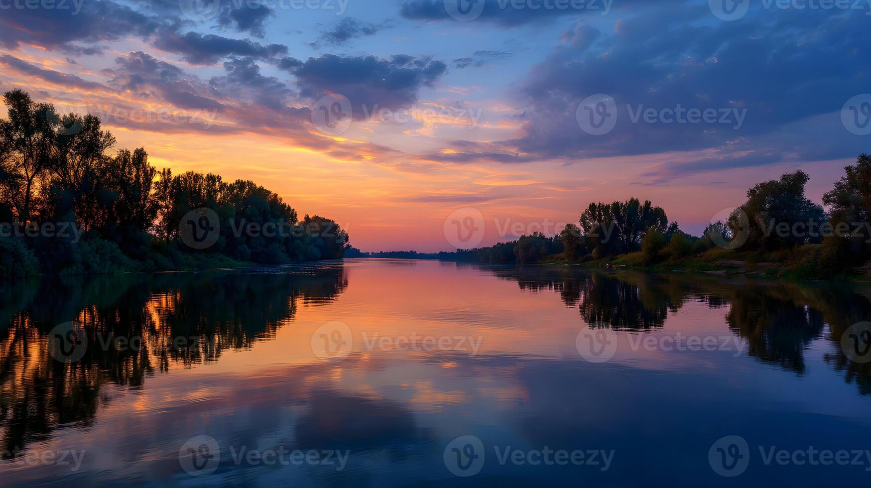 Tranquil sunset reflects on the water surface of a serene river surrounded by lush trees photo