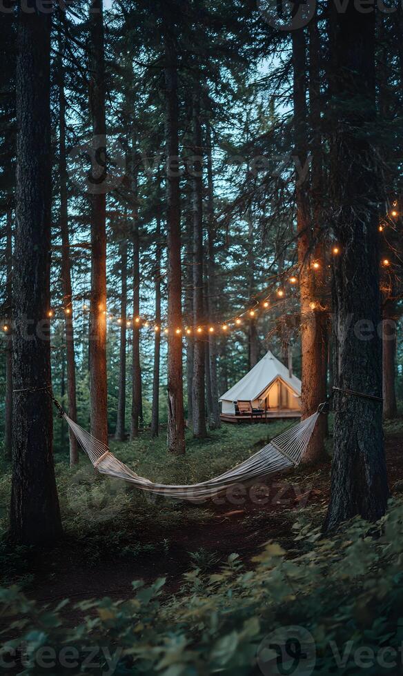 Tranquil wilderness retreat a hammock nestled between trees with a tent and soft glowing lights photo