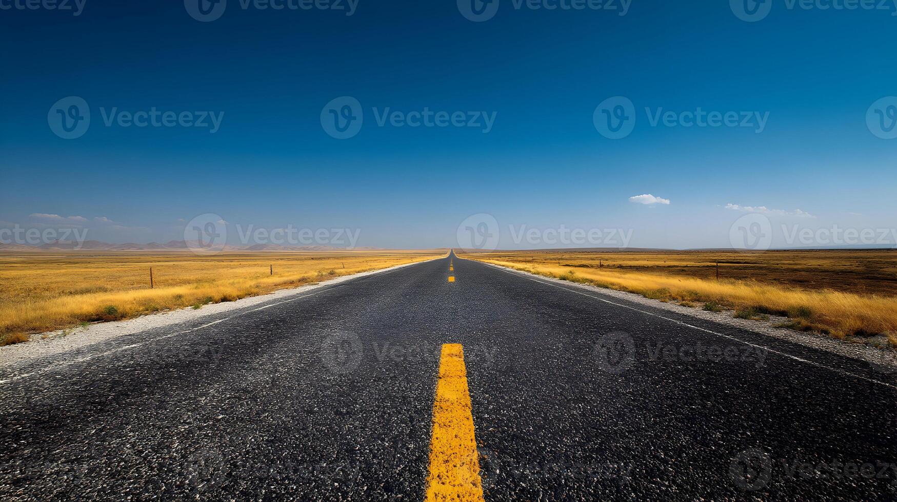 Open road leading into the horizon under a clear blue sky invites viewers to travel and explore photo