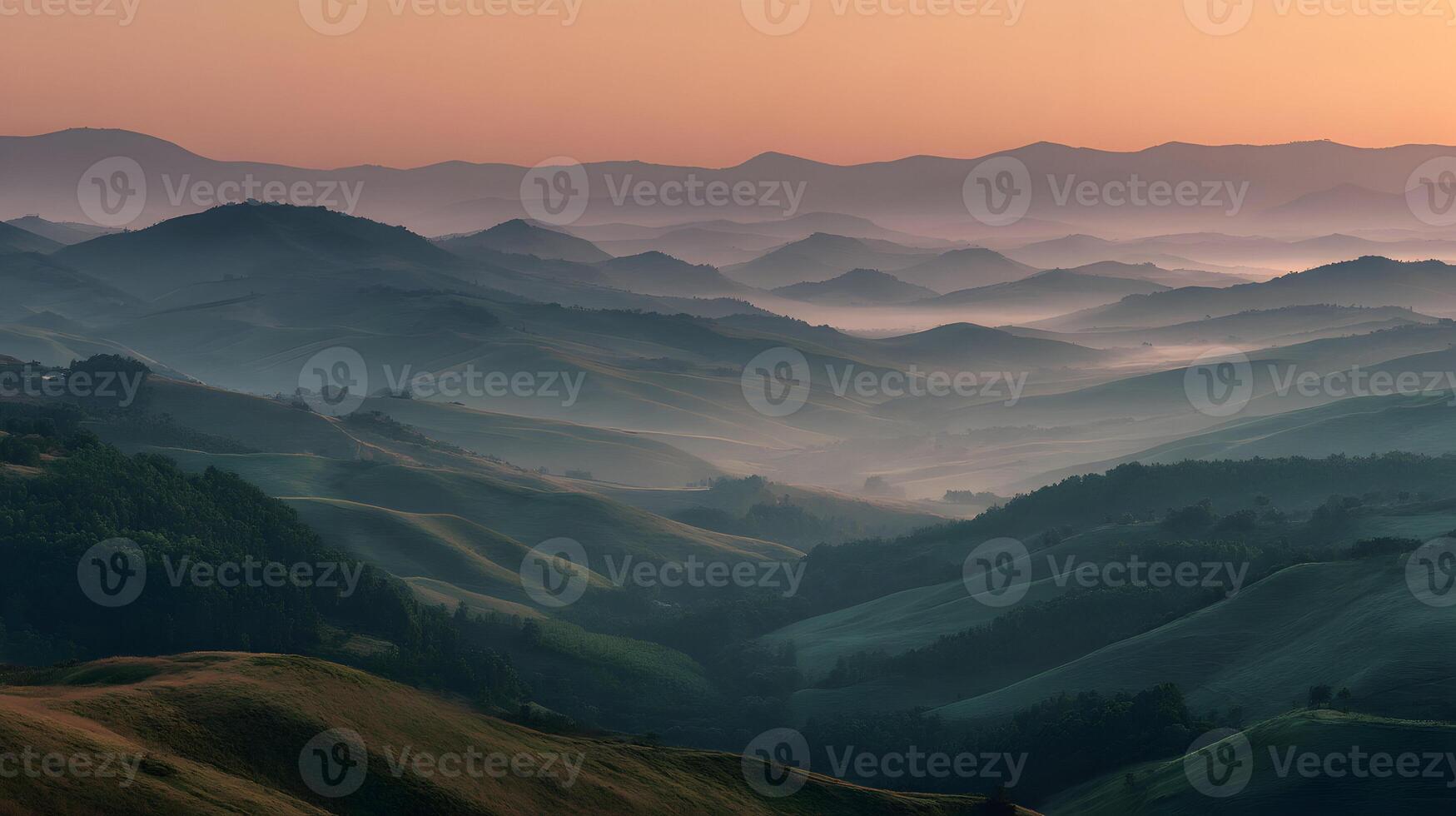 Majestic mountain range shrouded in a gentle morning mist illuminated by the warm glow of sunrise photo