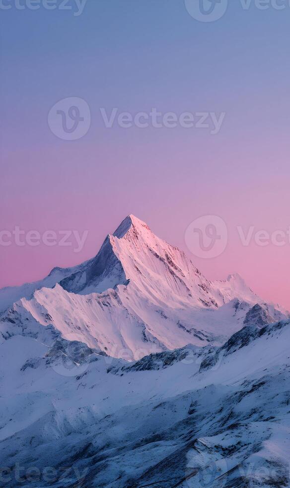 Majestic mountain peak covered in snow with a beautiful pink and purple sunset sky backdrop view photo