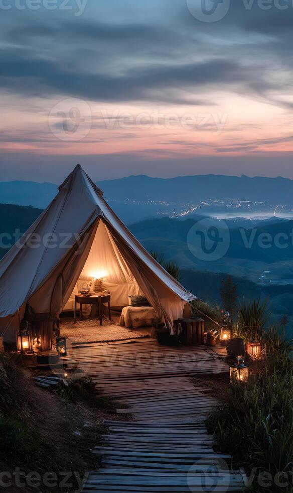 Idyllic mountain getaway camping tent illuminating the dusk with a stunning landscape view photo