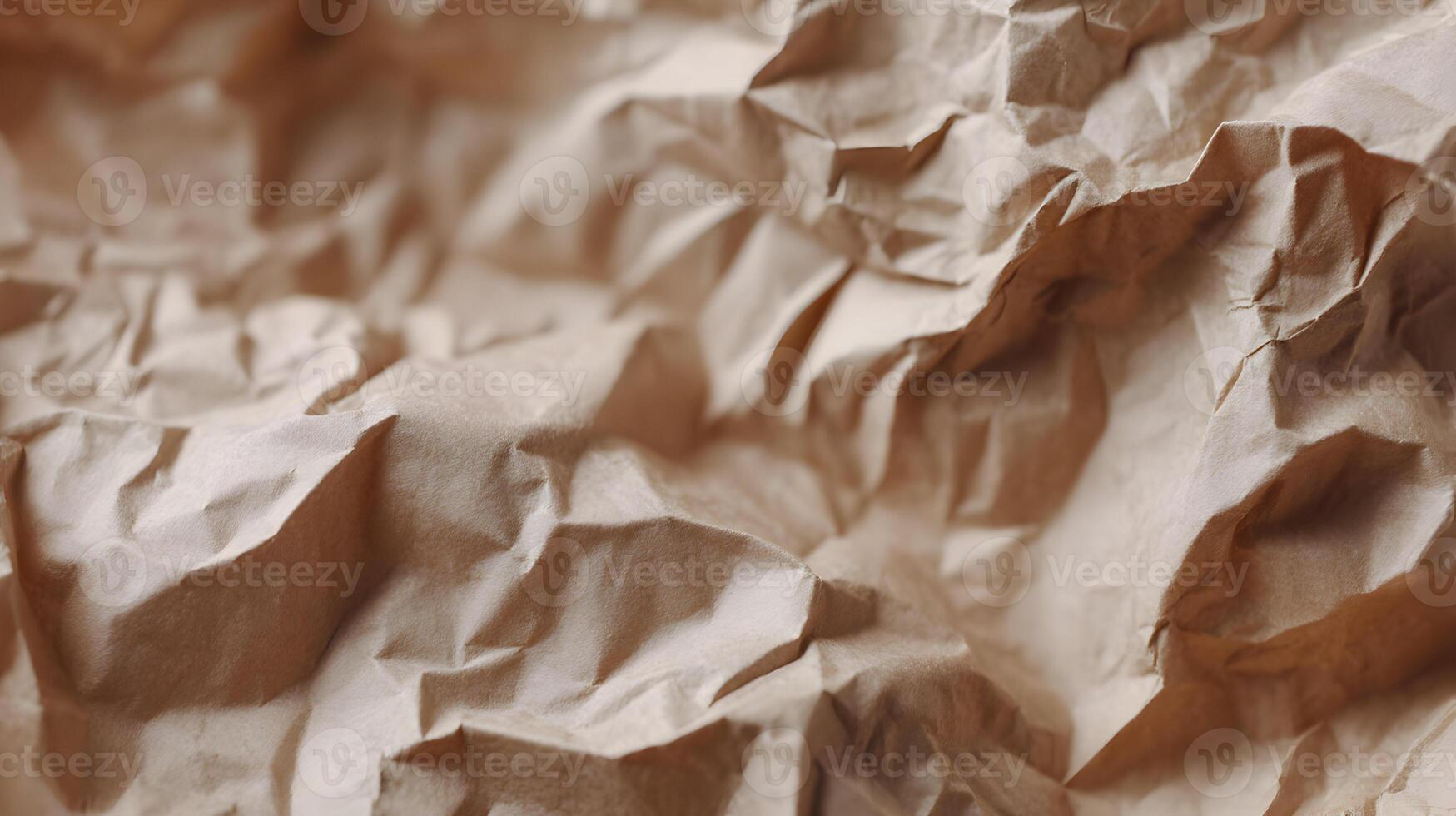 Subtle light plays across a landscape of brown crumpled paper creating an intriguing textural background photo