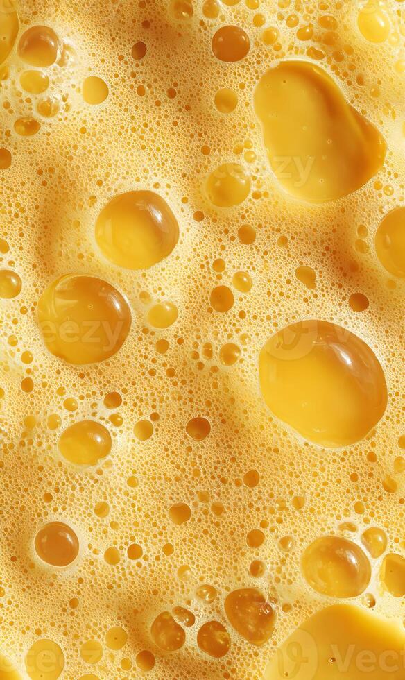 Abstract macro photograph showing a texture of golden beer foam with varied sized bubbles creating interesting shapes and forms photo