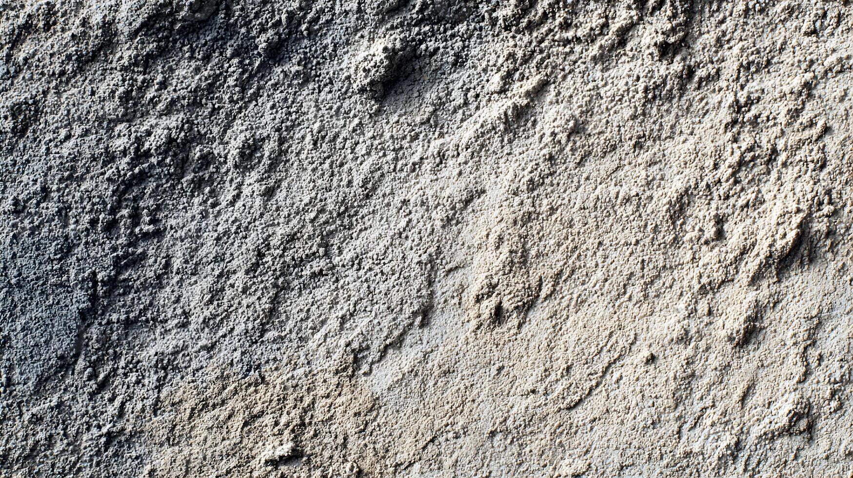 Textured surface featuring coarse aggregate and variations in color creates an abstract pattern photo