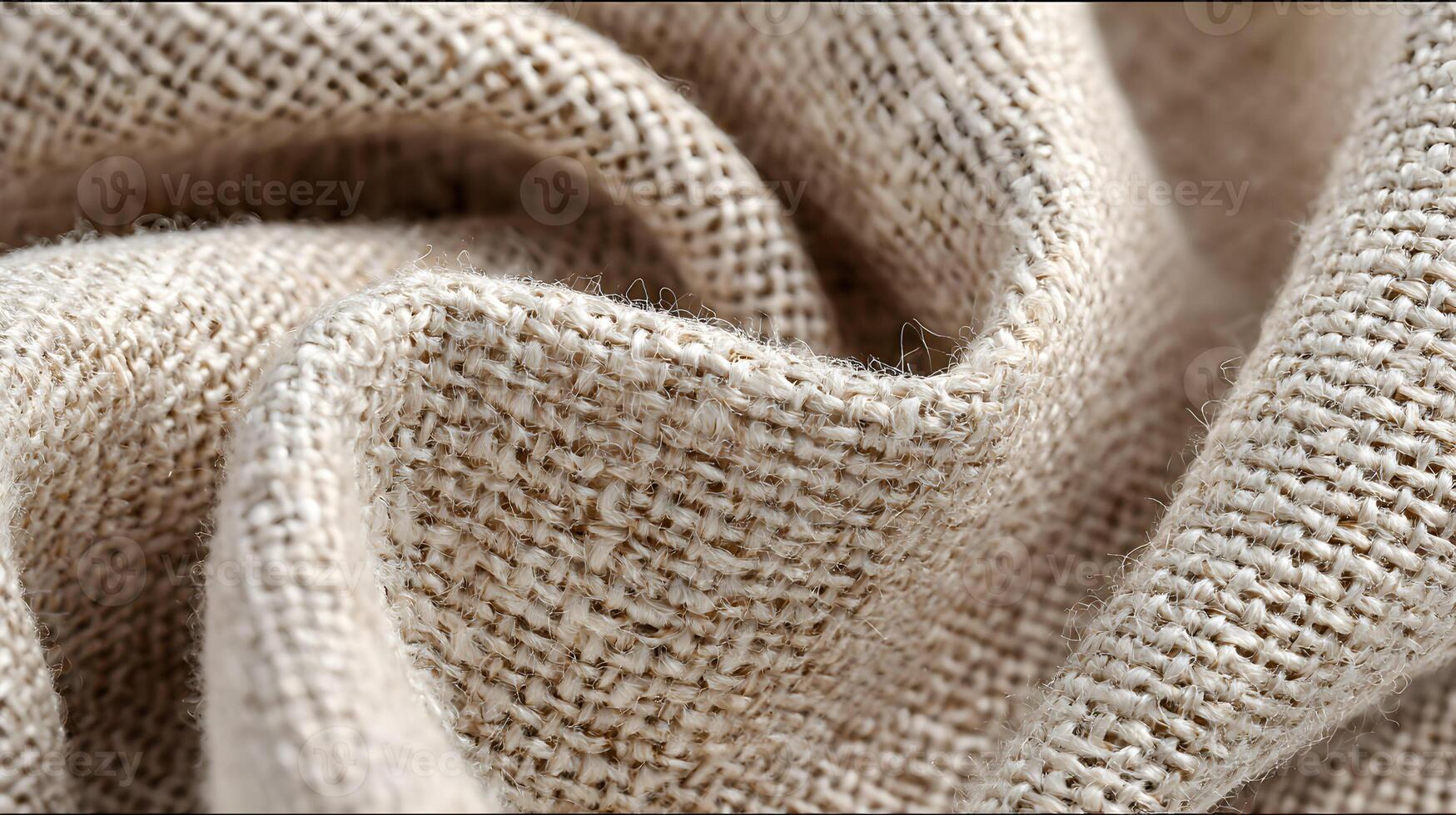 Detailed texture showcasing the weave of a natural beige burlap cloth with soft, smooth folds forming photo