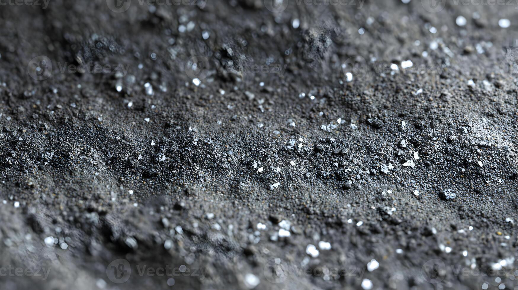 Close up of a rough dark textured surface with sparkling white crystals emphasizing depth and detail photo