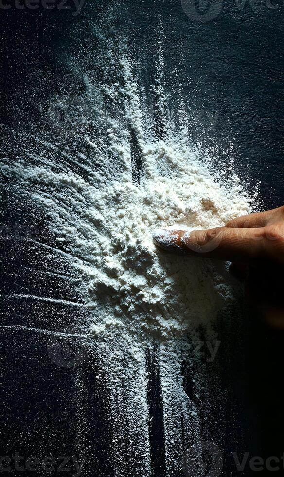 Creating flour art with a playful touch exploring textures and patterns with a single fingertip in a dark culinary space photo