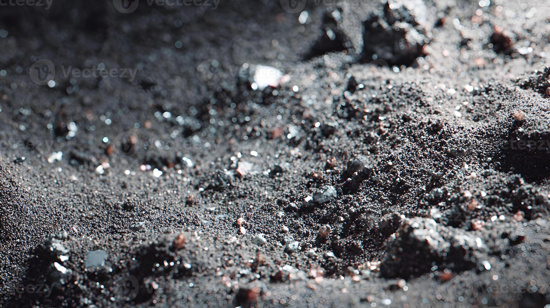 Close up of a textural landscape of dark sand and small rocks creating an interesting pattern photo