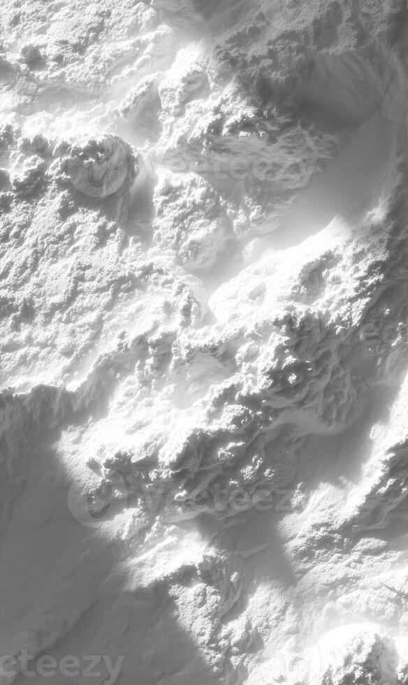 Aerial view of a rugged snowy mountain range bathed in sunlight casting shadows on the peaks landscape photo