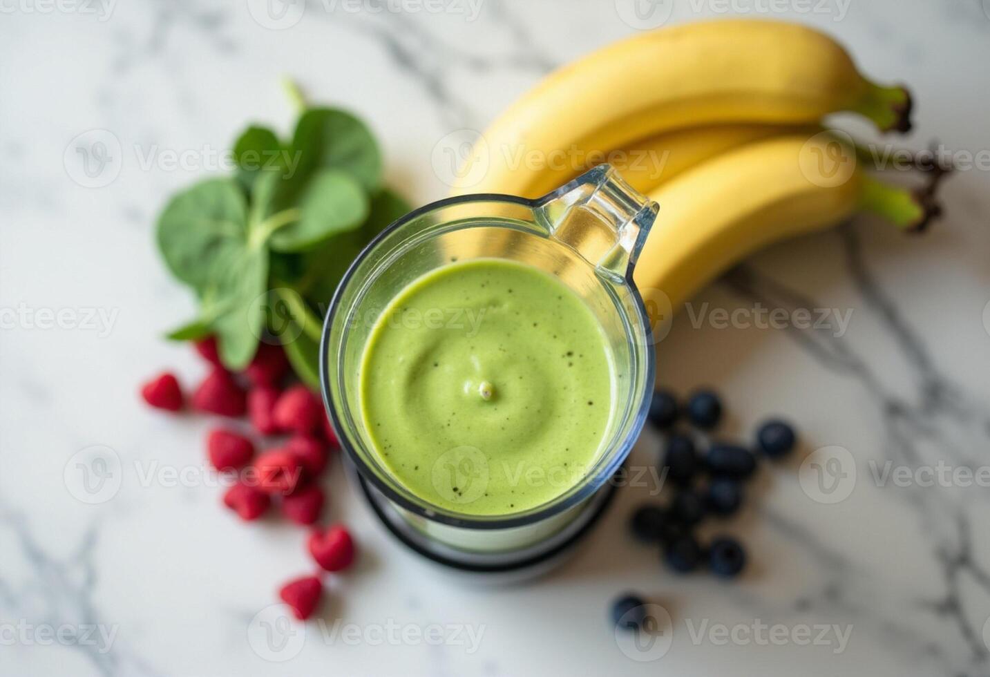 A blender with green smoothie and bananas photo