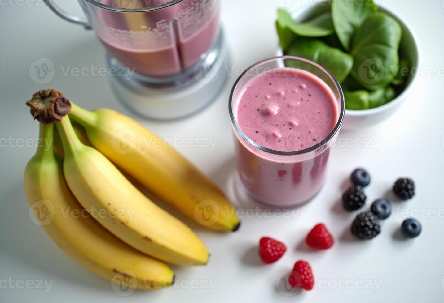 A blender with a banana, raspberries and a bowl of berries photo