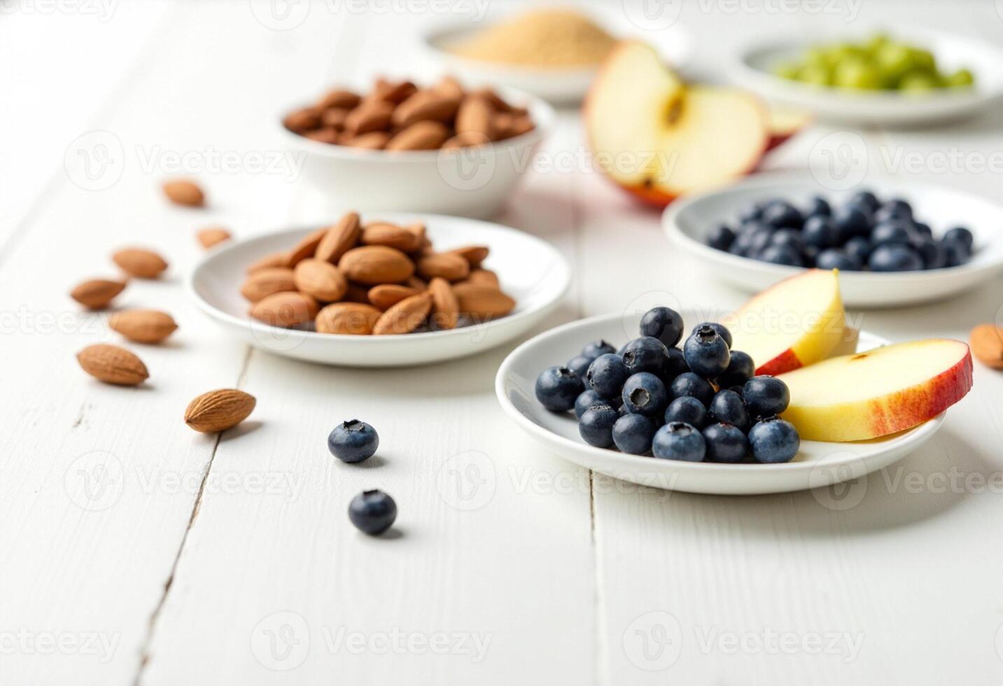 A variety of fruits and nuts in bowls on a white table photo
