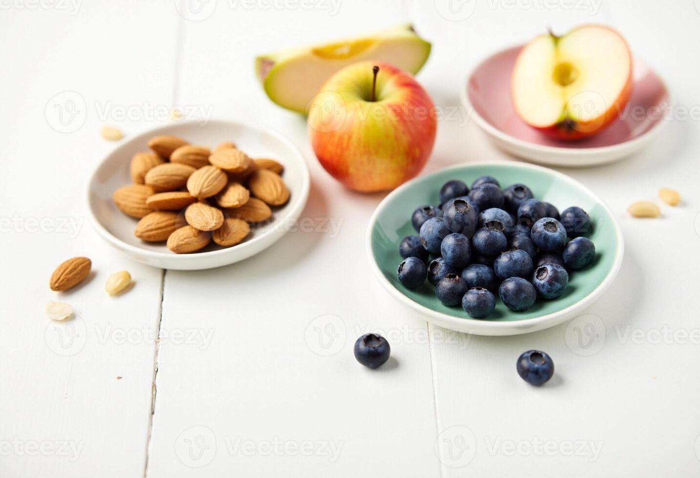 Blueberries, almonds, apples and blueberries on white table photo
