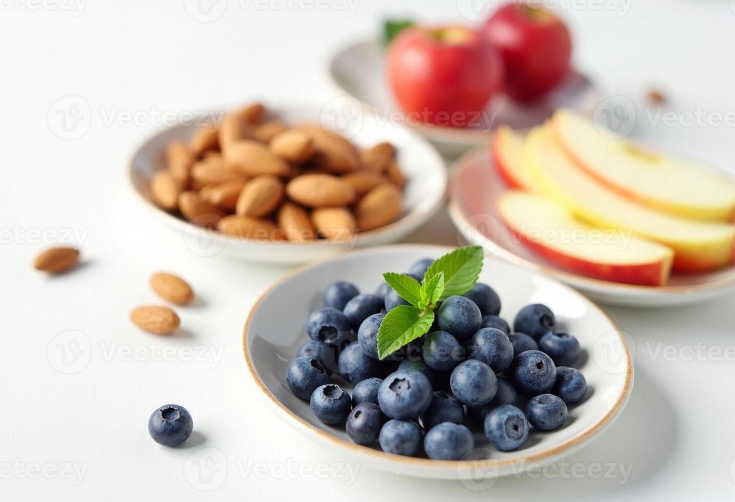 Blueberries, almonds, and apples in bowls photo