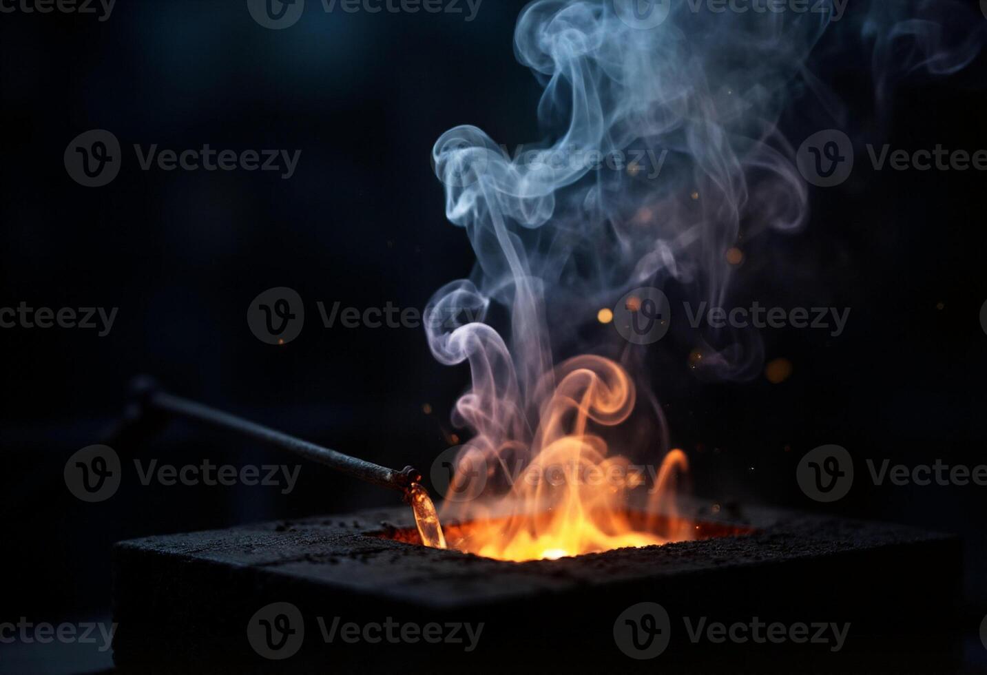 A blacksmith is using a torch to make a fire photo