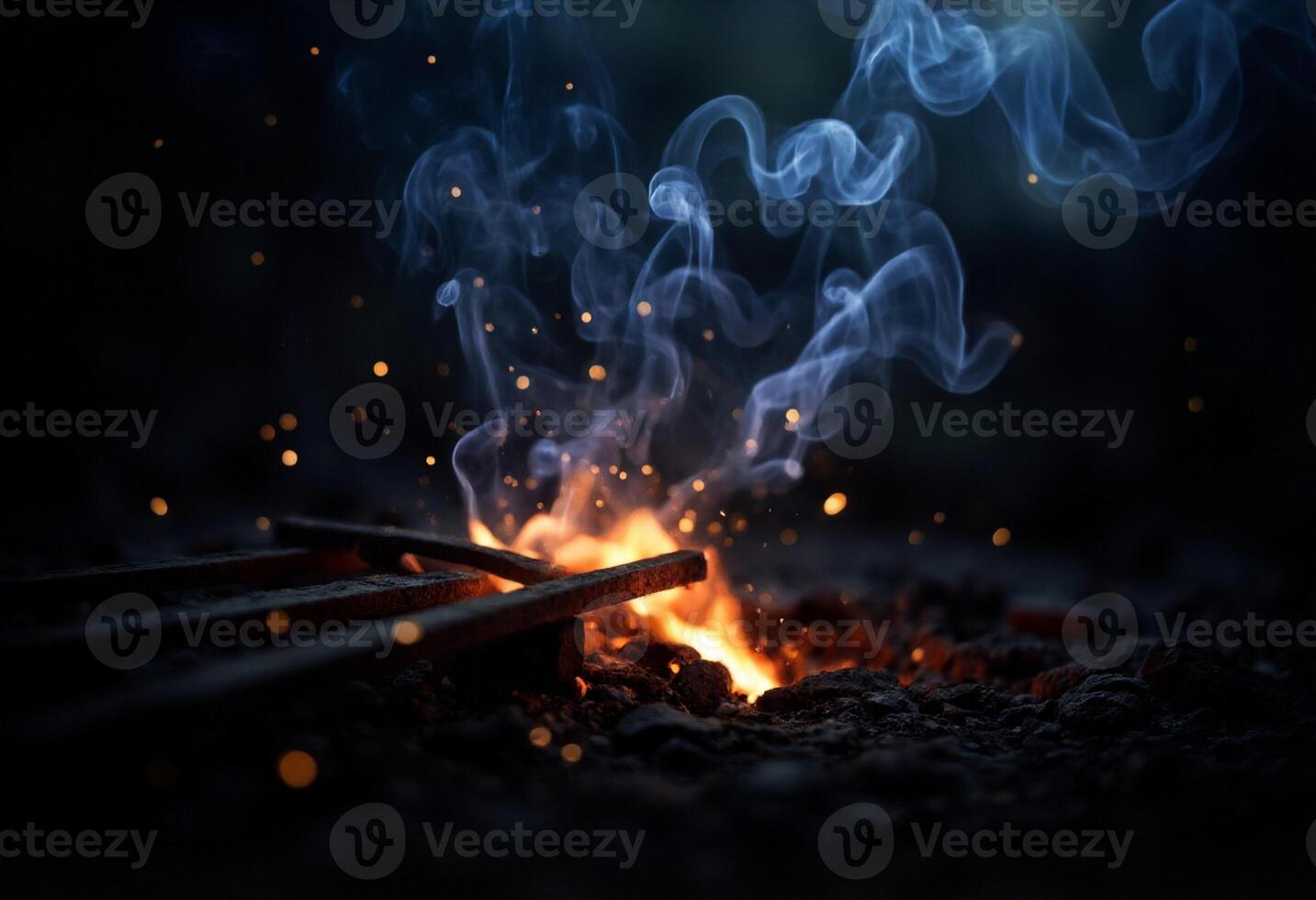 A fire is burning in the dark with smoke coming out photo