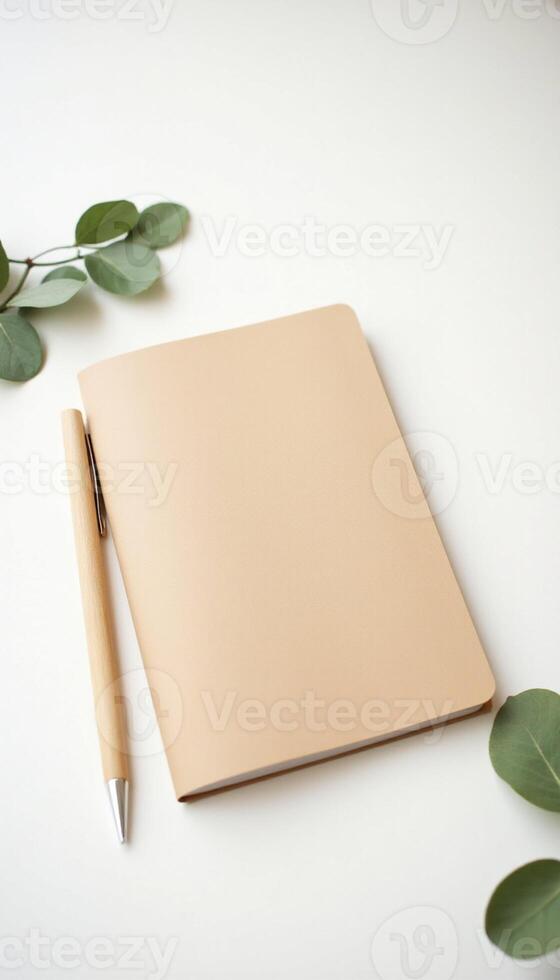 Notebook with pen and eucalyptus leaves on white background photo