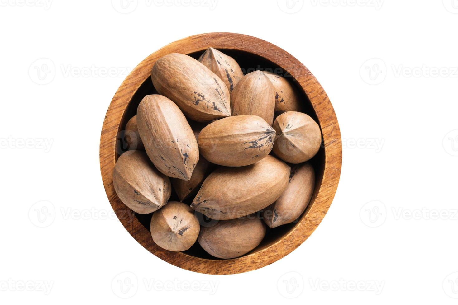 shelled pecan nuts raw in wooden bowl isolated on white background. Vegan food, top view. photo