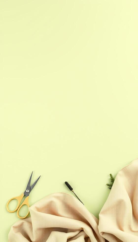 Soft fabric scissors mascara brush and green twig on light background for beauty photo