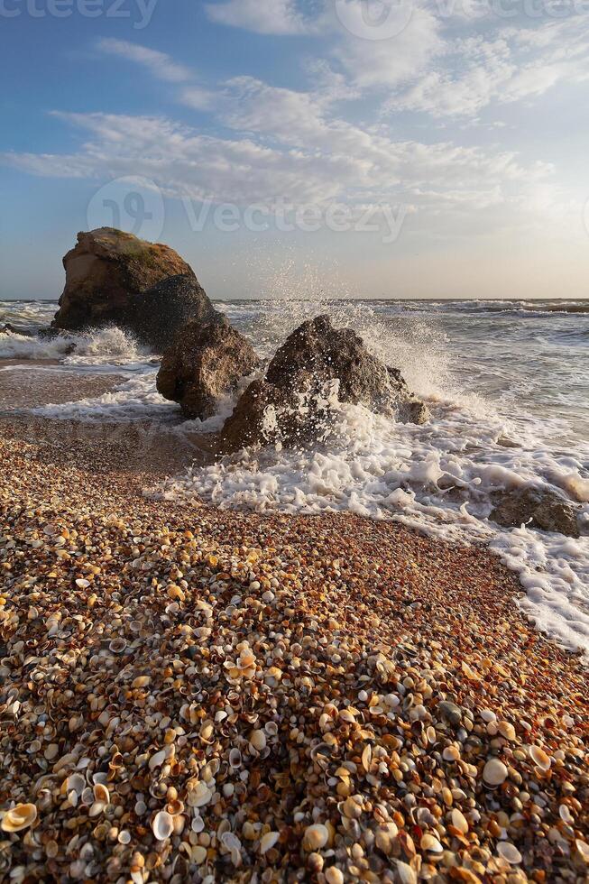 Waves collide with stones on the seashore. Nature photo
